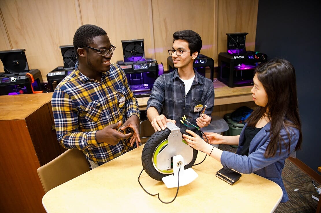 Students collaborating on new tech device