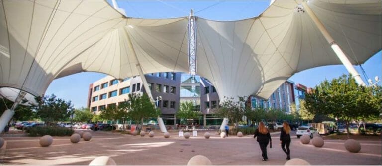 eople walking on SkySong campus under structural shade canopy